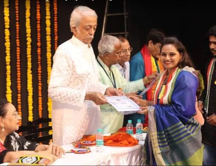 Founder receiving a certificate of appreciation on stage