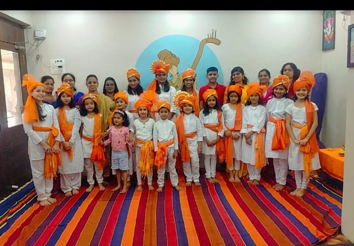 Children dressed in traditional orange pheta for a folk dance performance